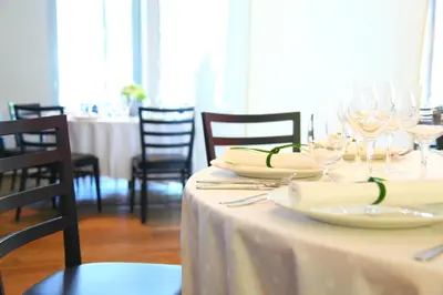 a table with plates and wine glasses on it at M Hotel in Ljubljana