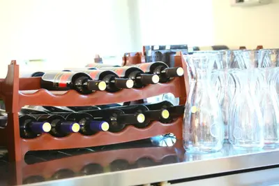 a rack of wine bottles and glasses on a counter at M Hotel in Ljubljana