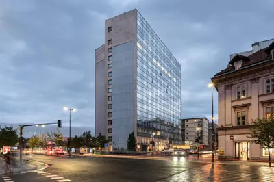 a tall glass building on a city street at Exe Lev in Ljubljana
