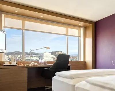 a bedroom with a window with a chair and a desk at Exe Lev in Ljubljana