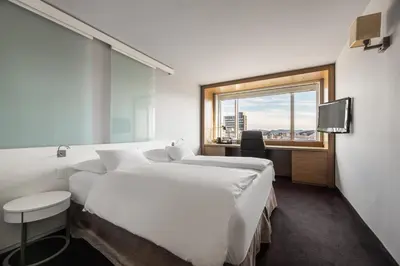 a hotel room with two beds and a window at Exe Lev in Ljubljana