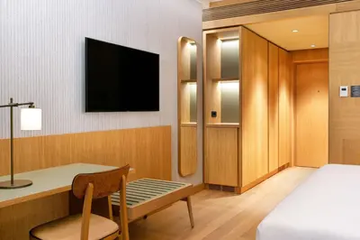 a room with a bed and a desk and a tv at Four Points by Sheraton Ljubljana Mons in Ljubljana