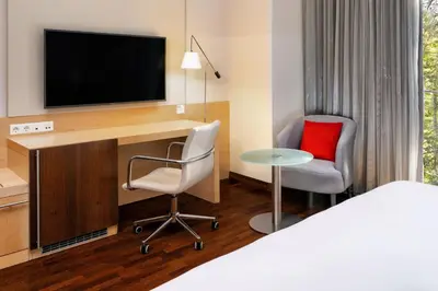 a hotel room with a desk with a tv and a chair at Four Points by Sheraton Ljubljana Mons in Ljubljana