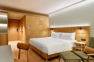 a hotel room with a bed and a chair at Four Points by Sheraton Ljubljana Mons in Ljubljana