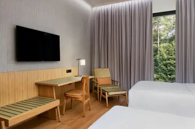 a hotel room with a bed and a desk and a tv at Four Points by Sheraton Ljubljana Mons in Ljubljana
