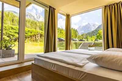 a bedroom with a bed and a large window at Hotel Kranjska Gora in Kranjska Gora