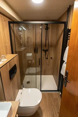a bathroom with a shower with a toilet and a sink at Hotel Kranjska Gora in Kranjska Gora