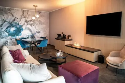 a living room with a couch and a flat screen tv at Elegans Hotel Brdo in Kranj