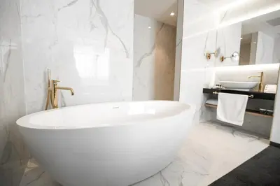 a white bathroom with a tub and a sink at Elegans Hotel Brdo in Kranj