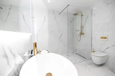a white bathroom with a shower and a toilet at Elegans Hotel Brdo in Kranj