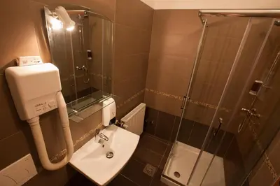 a small bathroom with a sink and a shower at ECO Hotel Center Postojna in Postojna