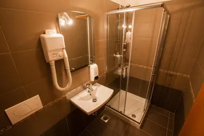 a small bathroom with a sink and a shower at ECO Hotel Center Postojna in Postojna