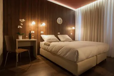 a bedroom with a bed and a table and a clock at ECO Hotel Center Postojna in Postojna