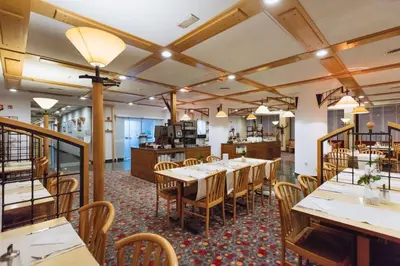 a dining room with wooden tables and chairs at Rogla – Hotel Rogla in Resnik