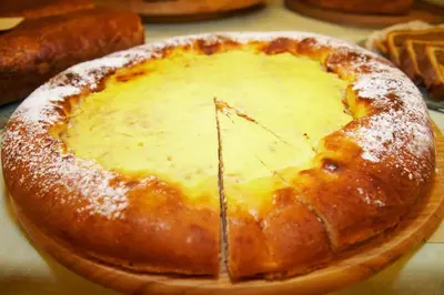 a cheese pizza sitting on a wooden plate at Rogla – Hotel Rogla in Resnik