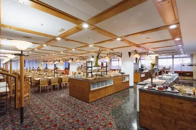 a dining room with a restaurant with tables and chairs at Rogla – Hotel Rogla in Resnik