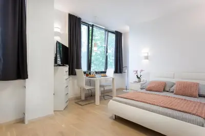 a bedroom with a bed and a desk and a table at Urban Style Apartments by Loft in Ljubljana