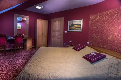 a bedroom with a large bed with purple walls at Hotel in restavracija Pod Roglo in Zreče