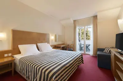 a hotel room with a bed and a television at Ramada Hotel & Suites Kranjska Gora in Kranjska Gora