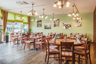 a dining room with wooden tables and chairs at Ramada Hotel & Suites Kranjska Gora in Kranjska Gora