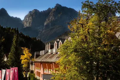 a red building with a mountain in the background at Ramada Hotel & Suites Kranjska Gora in Kranjska Gora