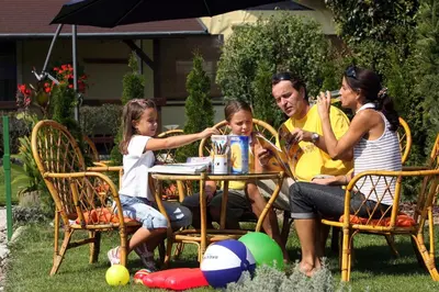 a family sitting at a table in the yard at Pri Ancki Sobe Rooms Accomodation Ljubljana suburbs in Medvode