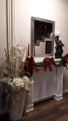 a mirror and a vase with flowers in a room at Sport Manca Garni Hotel in Radovljica