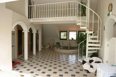 a hallway with a staircase and a tub in a house at Sport Manca Garni Hotel in Radovljica