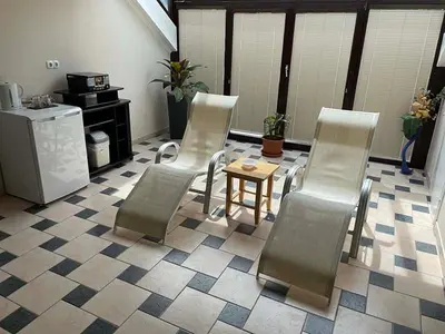 a room with three chairs and a table and a kitchen at Sport Manca Garni Hotel in Radovljica