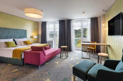 a hotel room with a bed and a living room at Bled Rose Hotel in Bled