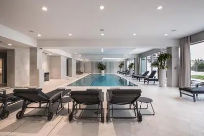 a lobby with a pool with chairs and a table at Bled Rose Hotel in Bled