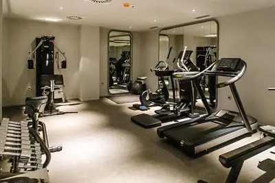 a gym with several tread machines and mirrors at Bled Rose Hotel in Bled