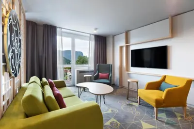 a hotel room with a couch and chairs and a tv at Bled Rose Hotel in Bled