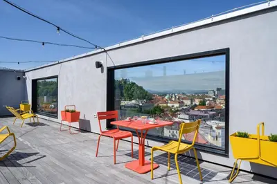 a patio with a table and chairs on a balcony at B&B Hotel Ljubljana Park in Ljubljana