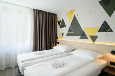 a hotel room with two beds and a window at B&B Hotel Ljubljana Park in Ljubljana
