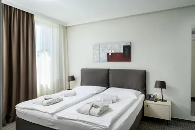 a large white bed in a room with a window at B&B Hotel Ljubljana Park in Ljubljana