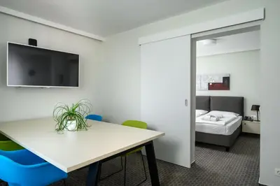 a room with a table and chairs and a bed at B&B Hotel Ljubljana Park in Ljubljana