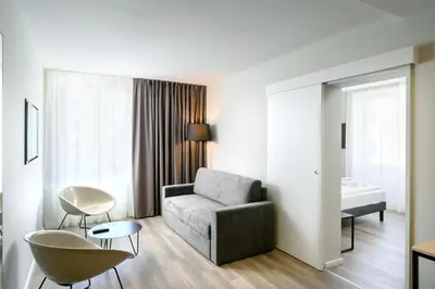 a living room with a couch and a bed at B&B Hotel Ljubljana Park in Ljubljana