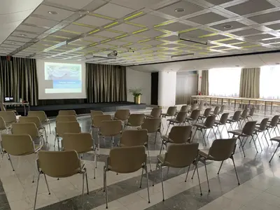 a room with rows of chairs and a projection screen at Hotel Alp in Bovec