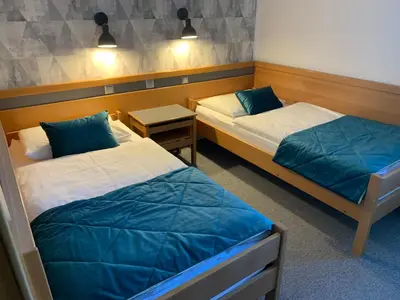 a room with two beds and a night stand at Hotel Alp in Bovec