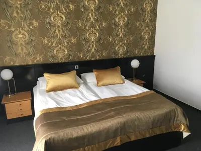 a bedroom with a large bed with gold pillows at Hotel Alp in Bovec