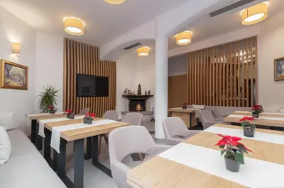 a restaurant with tables and chairs and a fireplace at Garni Hotel Miklič in Kranjska Gora