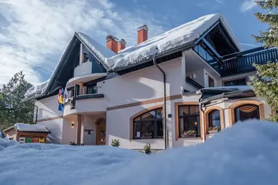 a white house with snow on the ground at Garni Hotel Miklič in Kranjska Gora