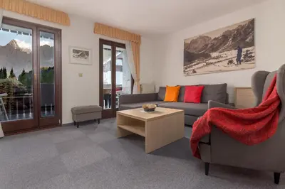a living room with a couch and a table at Garni Hotel Miklič in Kranjska Gora