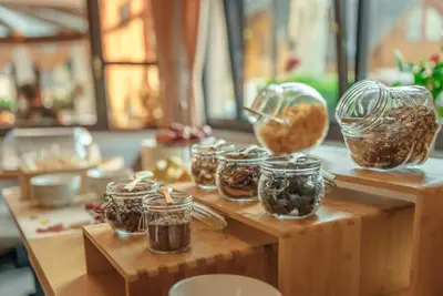 a table with jars of food on a wooden table at Garni Hotel Miklič in Kranjska Gora