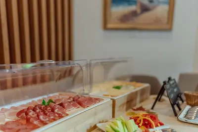 a buffet with meats and vegetables on a table at Garni Hotel Miklič in Kranjska Gora