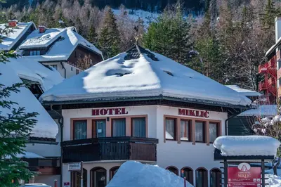 a hotel in the mountains covered in snow at Garni Hotel Miklič in Kranjska Gora