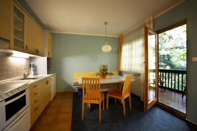 a kitchen with a table and chairs and a balcony at Terme Zreče – Vile Terme Zreče in Zreče