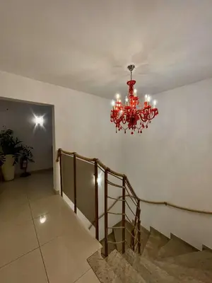 a red chandelier in a hallway with stairs at Aparthotel Gaja in Bled