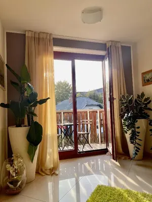 a living room with a sliding glass door with a balcony at Aparthotel Gaja in Bled